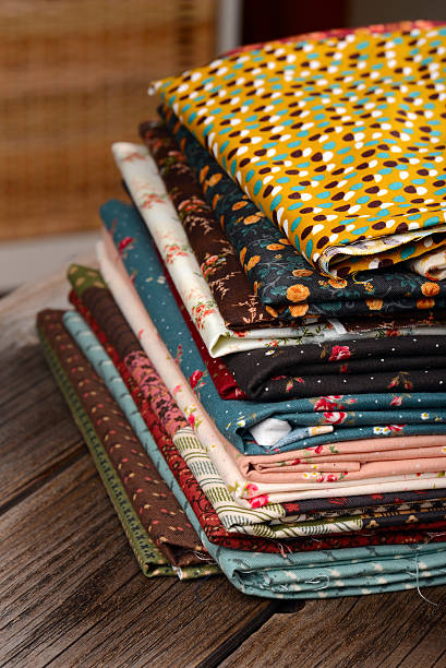 istock heap of cloth fabrics on wooden table 515787025