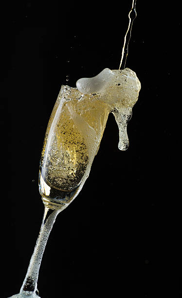 istock Glass of champagne with splash, isolated on black background 515787380