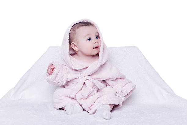 cute baby sitting on a chair in a pink bathrobe