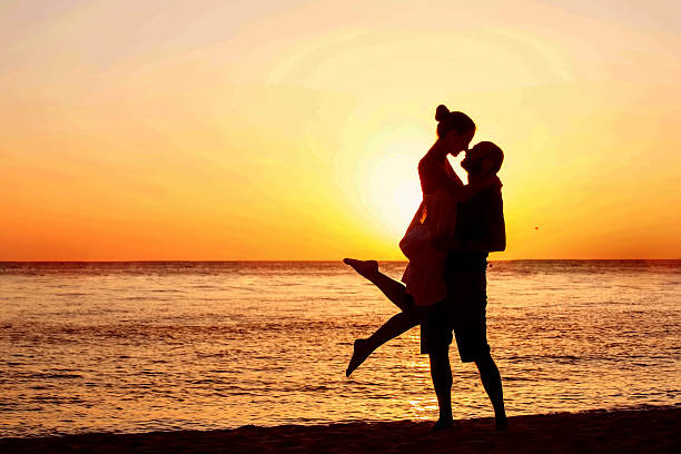 istock Romantic couple on the beach at colorful sunset on background 515789420