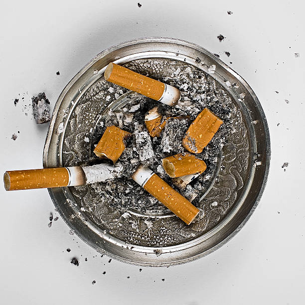 пепельница с сигарета butts - cigarette addiction shock smoking стоковые фото и изображения