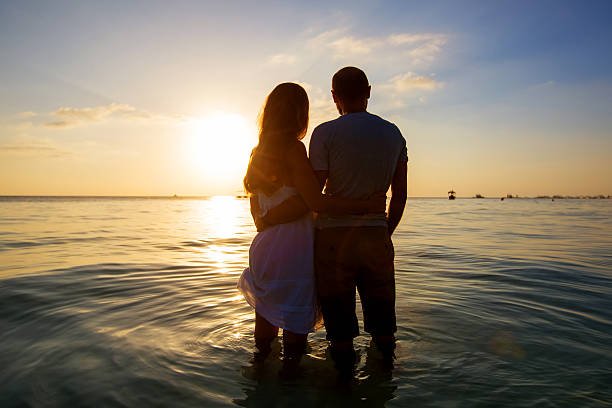 istock Romantic couple on the beach at colorful sunset on background 515789486