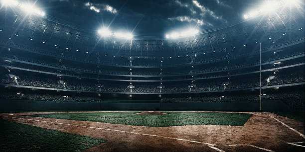 Baseball stadium A wide angle of a outdoor baseball stadium full of spectators under a stormy night sky and rain. The image has depth of field with the focus on the foreground part of the pitch. stadium stock pictures, royalty-free photos & images