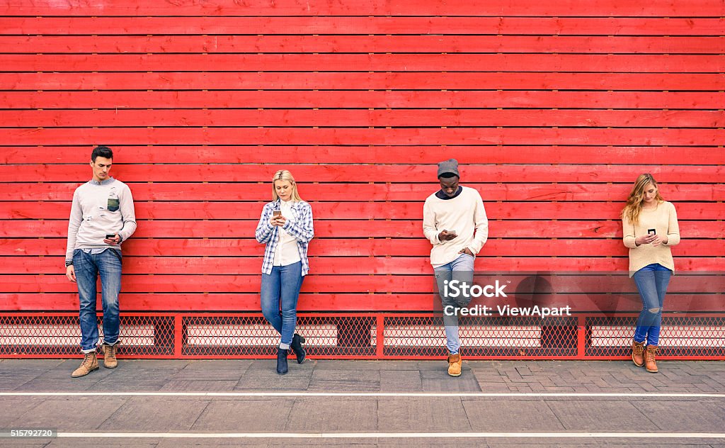 Grupo de multirracial moda sus amigos usando teléfono inteligente al aire libre - Foto de stock de Rojo libre de derechos