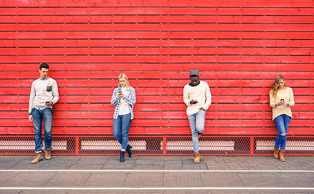 multirazziale gruppo di moda amici utilizzando smartphone all’aperto - red cell foto e immagini stock