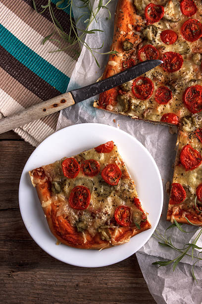 istock pizza on baking paper and wooden board 515803968