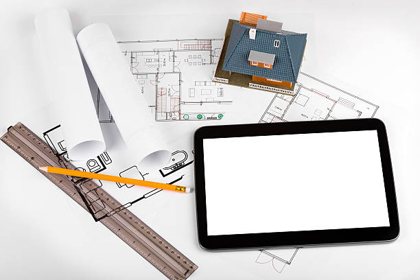 istock blank tablet and house scale model on architectural blueprints 515804646