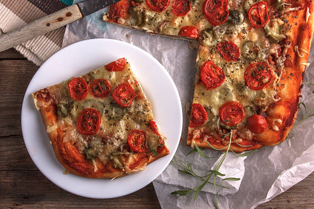 istock pizza on baking paper and wooden board 515804656