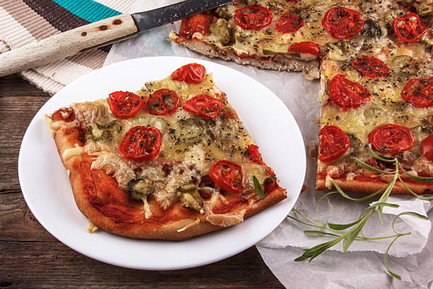 istock pizza on baking paper and wooden board 515805328