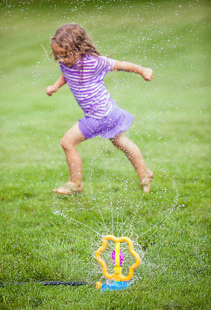 istock Girl Playing in Sprinkler 515807135
