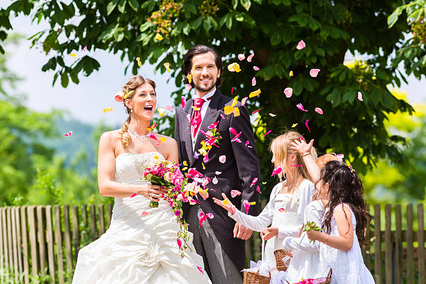 istock Wedding couple and bridesmaid showering flowers 515807926