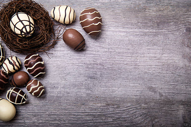Chocolate Easter Eggs in nest Over Wooden Background