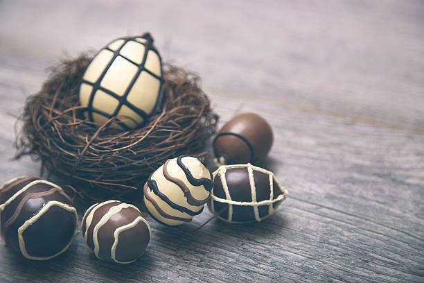 Chocolate Easter Eggs in nest Over Wooden Background