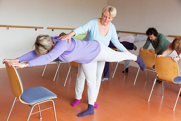 istock instructor and active senior women in yoga class with chairs 515808994