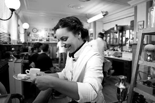 waitress serving a coffee at barbershop