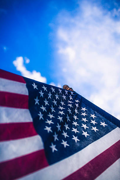 istock American Flag Against Blue Sky 515811257