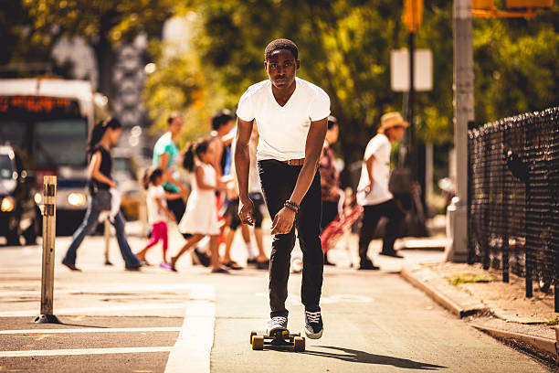 Young man riding on longboard in New York streets.