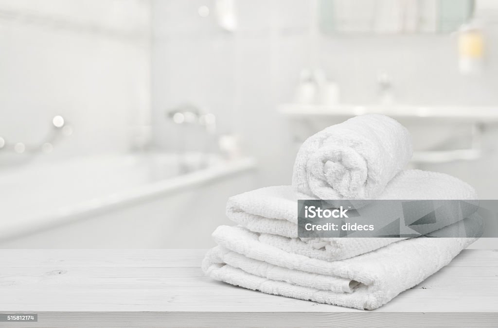 Stack of folded white spa towels over blurred bathroom background Towel Stock Photo