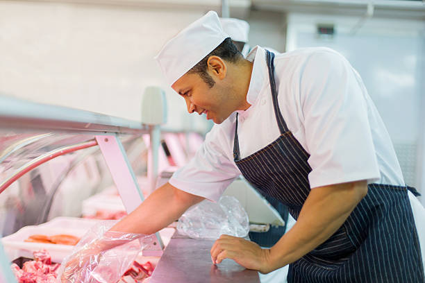 istock butcher picking piece of meat 515812722