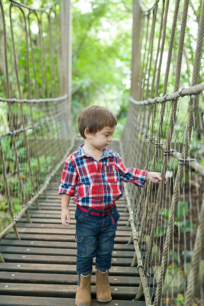 istock Caucasian boy on suspension bridge 515813411