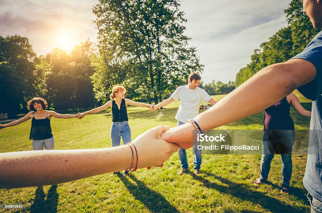 Friends holding hands in the park 14-15 Years Stock Photo