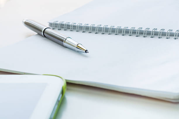 istock Open notebook with metallic ball pen and tablet 515814660