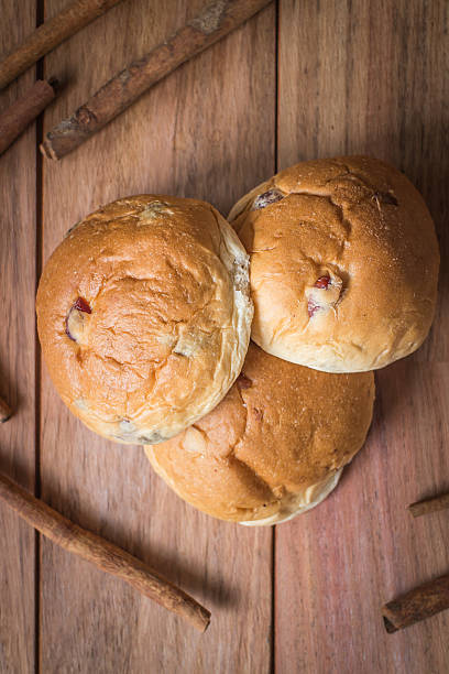 istock Buns with raisins on wood texture background 515825092