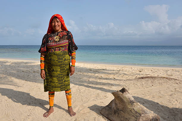 Traditional Kuna indian tribal woman on the beach San Blas, Panama - March 5, 2016: Traditional Kuna women indian on Aroma  Island at the San Blas archipelago in Panama. She is wearing the traditional clothing with mola embroidery and colorful bracelets, made of hundreds of small beads and worn on both the arms and legs. kuna yala stock pictures, royalty-free photos & images