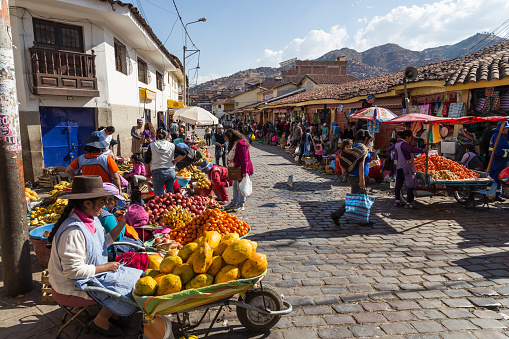 Cusco, Peru - August 08, 2015: People selling and buying fruits at a market in the steets.