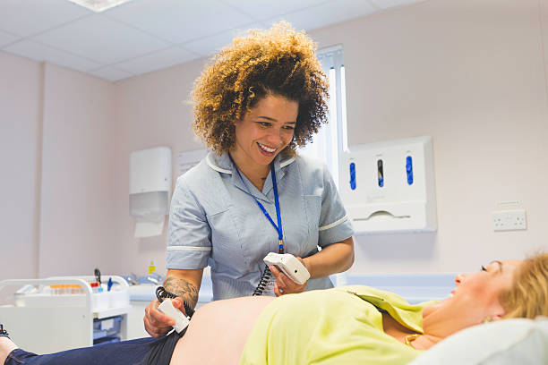Pregnant Woman Having an Ultrasound Pregnant woman having an ultrasound at doctor's office, female gynaecologist using a transducer midwife photos stock pictures, royalty-free photos & images