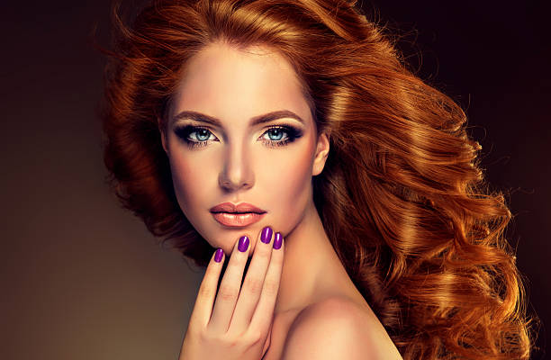 модель с длинные волнистые красные волосы и фиолетовый ногтей. - make up women glamour horizontal стоковые фото и изображения
