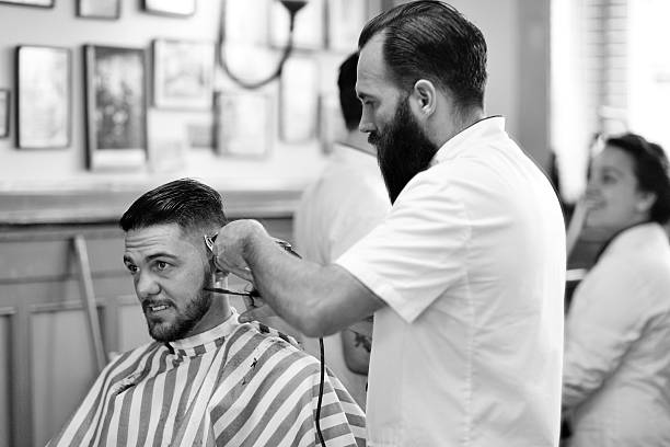 istock barber working on client in barbershop 515839319