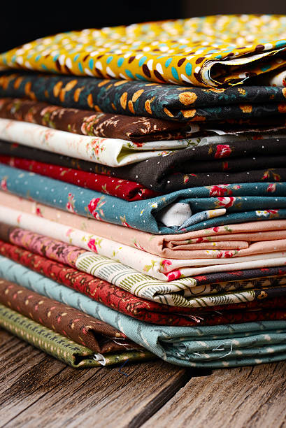 istock heap of cloth fabrics on wooden table 515841907