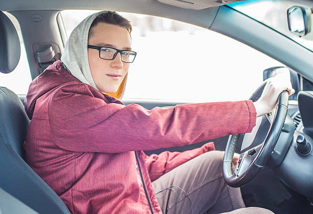 istock Young man in glasses driving a car. 515849426