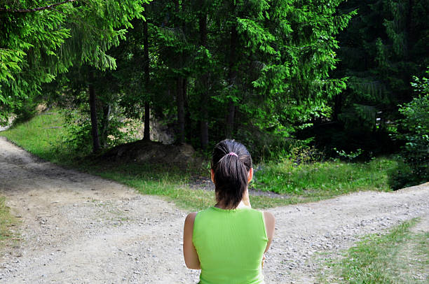 dziewczyna z wyborem w pobliżu forked road - decisions nature road street zdjęcia i obrazy z banku zdjęć