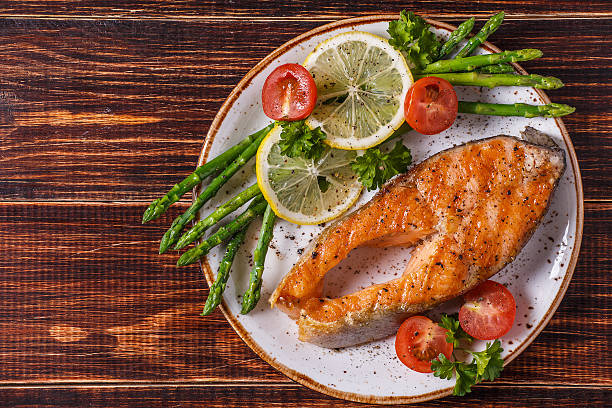 istock Grilled salmon steak served with asparagus, tomato and lemon. 515850170