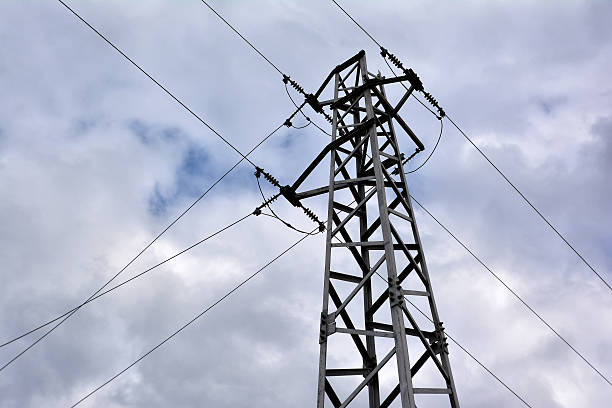 istock Electricity transmission pylon against cloudy sky 515850320