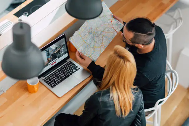 Photo of Backpackers Looking For Apartment On Their Laptop.