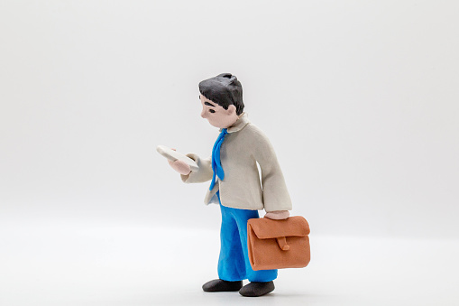 handmade clay figurine: office man reading mobile phone on the way