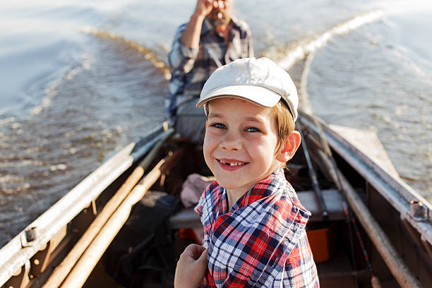 feliz menino andando em um barco com seu avô - fishing lake grandfather grandson - fotografias e filmes do acervo