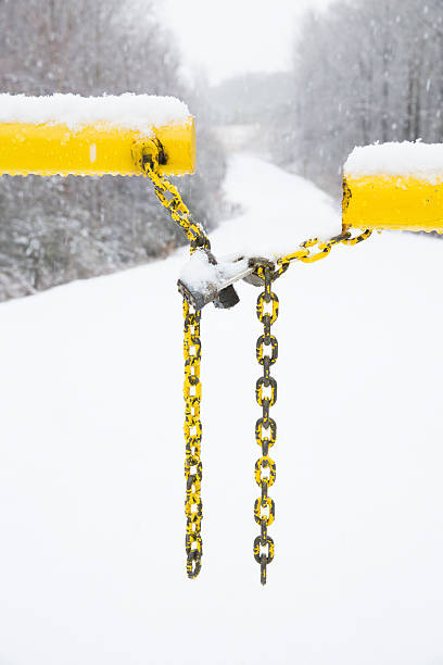 istock Snow covered gate and lock and snow covered road 515854634