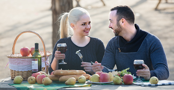 Portrait of young adults drinking wine at table in nature outdoor