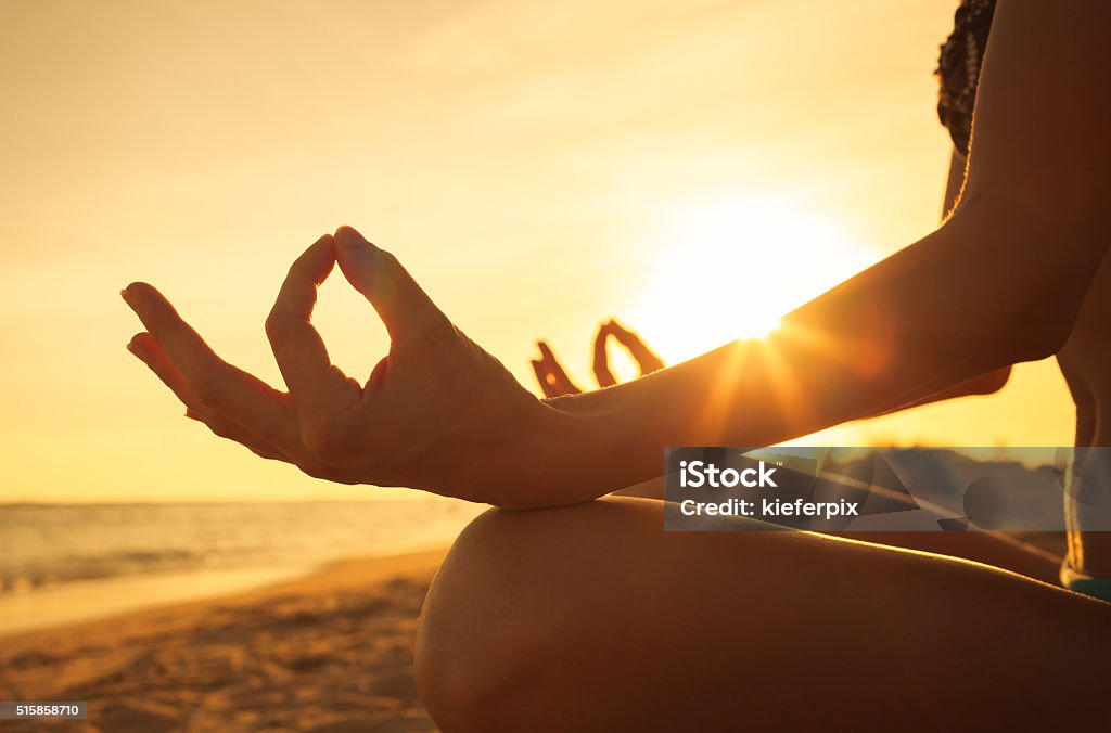Peaceful meditation Close-up hand of a woman meditating  on the beach. Yoga Stock Photo