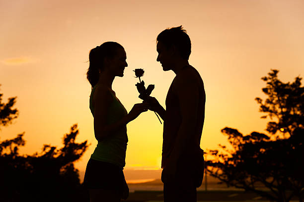 Man giving woman a rose Man giving woman a rose. (romance and dating concepts) flower outdoors day loving stock pictures, royalty-free photos & images