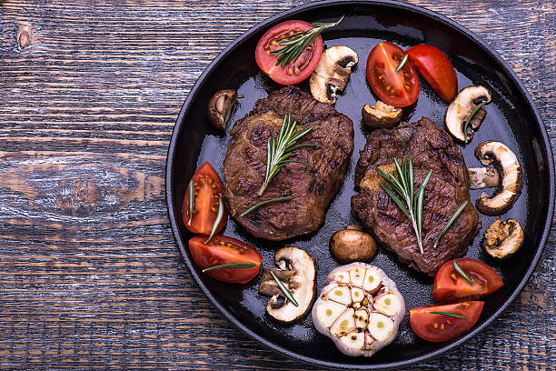 istock Beef Steak, salt, pepper, garlic, rosemary on black board, background. 515860578
