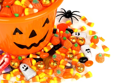 Halloween Jack o Lantern pail overhead view with pile of candy