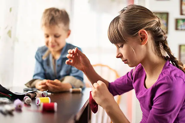 Photo of Brother and sister crafting and sewing