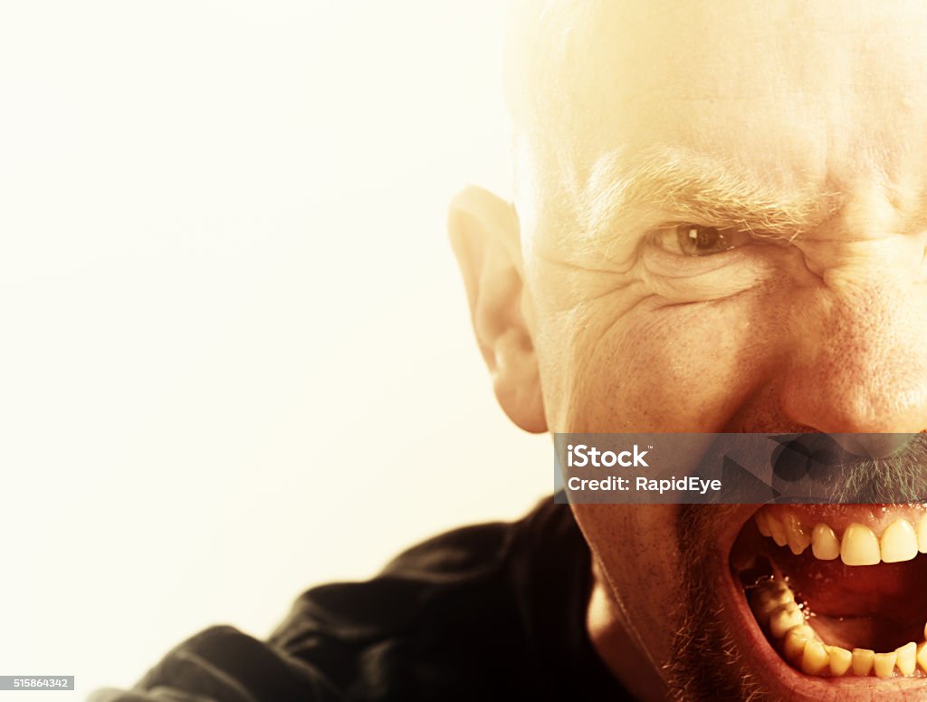 Furious man yells, out of control or insane Cropped head and shoulders portrait of  an out-of-control man snarling and yelling in absolute fury or possible insanity. People Stock Photo