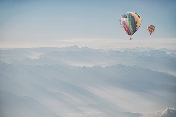 istock Hot air balloon flying over snowcapped mountain 515865154