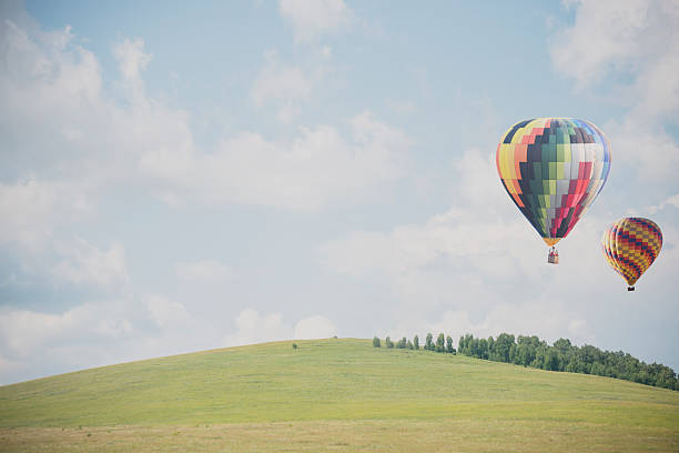 istock Hot air balloon flying over grass field 515882618